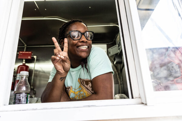 Ruthie’s For Good team member smiling and serving guests from the food truck window