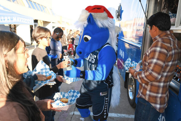 Ruthie’s For Good food truck serving grilled cheese to a crowd at a Dallas Mavericks community event