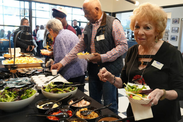 Ruthie’s For Good catering buffet with guests serving salad and sides at a Dallas event